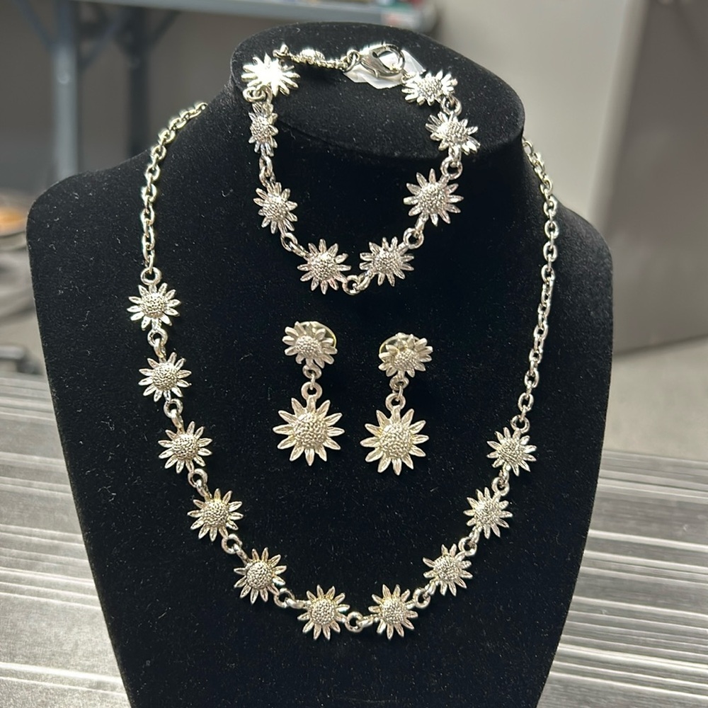 Silver tone flower necklace, bracelet, and earrings.